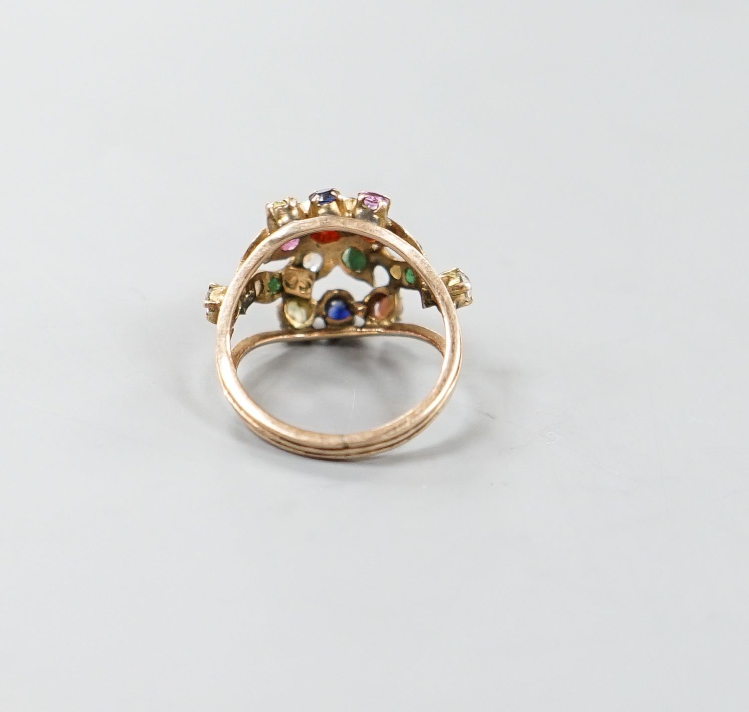 An early 20th century Arts & Crafts yellow metal and multi gem set set cluster ring, size H/I, gross weight 3.6 grams.